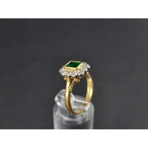 277 - An 18ct gold emerald and diamond cluster ring, the central emerald surrounded by twelve brilliant cu... 