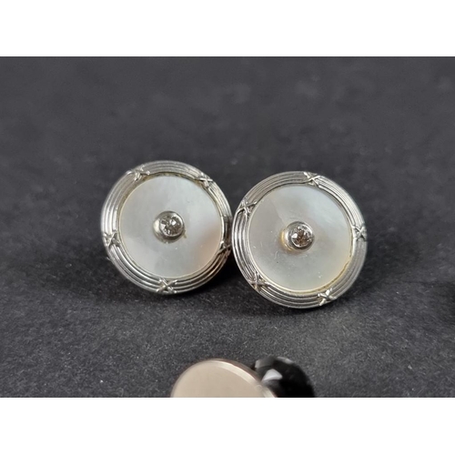 286 - A pair of Edwardian precious metal and mother-of-pearl cufflinks, each of the four 13mm circular hea... 