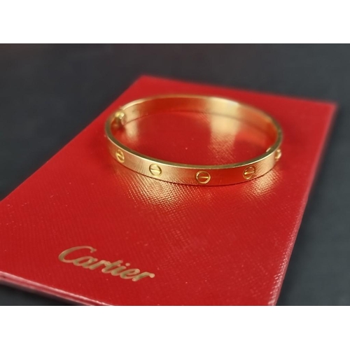 303 - A Cartier 'LOVE' bracelet, with screw motif design, stamped '750', size 17, No.YT5654, complete with... 