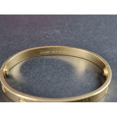 303 - A Cartier 'LOVE' bracelet, with screw motif design, stamped '750', size 17, No.YT5654, complete with... 