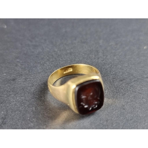 313 - A yellow metal carnelian intaglio signet ring, decorated Roman Centurion, stamped 18ct, size N.... 