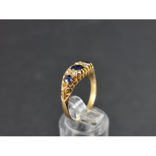 313A - A yellow metal sapphire and diamond ring, set three sapphires interspersed with four diamonds, hallm... 