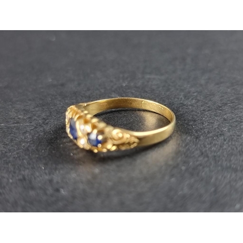 313A - A yellow metal sapphire and diamond ring, set three sapphires interspersed with four diamonds, hallm... 