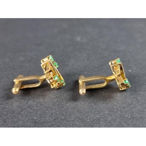 319 - A pair of yellow metal and emerald set cufflinks, the heads 19mm, indistinctly marked.... 