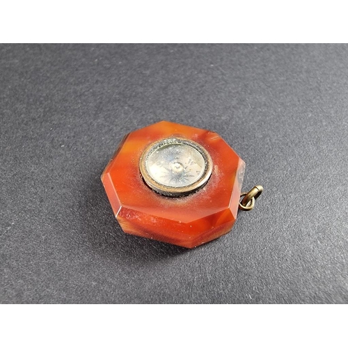 340 - A red agate octagonal compass pendant, 22mm; together with a base metal riding crop bar brooch. (2)... 