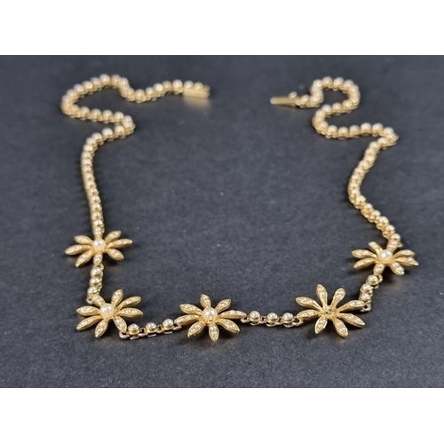 355 - A Victorian or Edwardian yellow metal necklace, decorated five stylised seed pearl flowerheads, (one... 