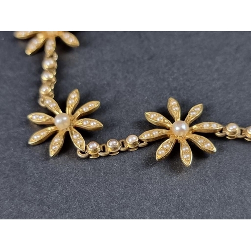 355 - A Victorian or Edwardian yellow metal necklace, decorated five stylised seed pearl flowerheads, (one... 