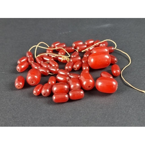 400 - A graduated cherry amber barrel form bead necklace, unstrung, gross weight 89.2g.