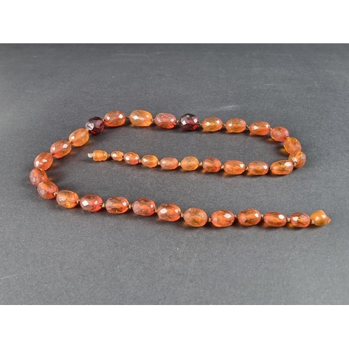 401 - An amber faceted and graduated bead necklace, 64cm, gross weight 50g.