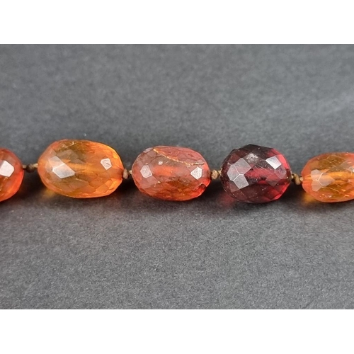 401 - An amber faceted and graduated bead necklace, 64cm, gross weight 50g.