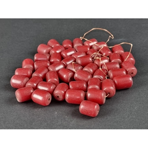 404 - A cherry amber necklace, the beads of barrel form, partly unstrung, 195g approximately.... 