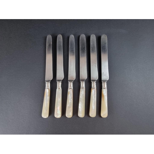 72 - A set of six mother of pearl handled table knives, with silver collars.