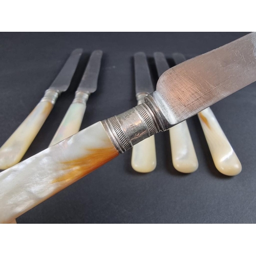 72 - A set of six mother of pearl handled table knives, with silver collars.