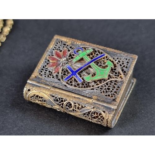 96A - A gilt metal filigree and enamel novelty book vesta case, containing a plated crucifix and chain.... 