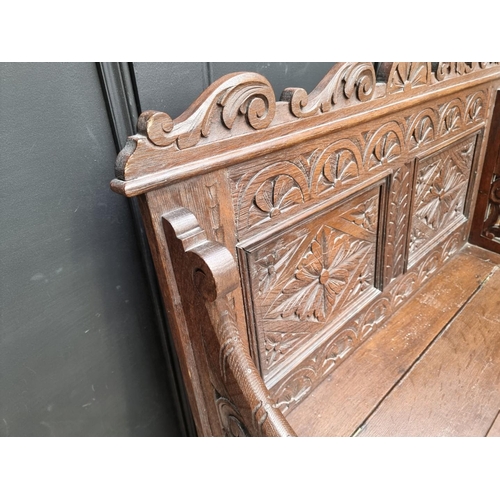 1073 - A circa 1900 carved oak box seat settle, 106cm wide. 