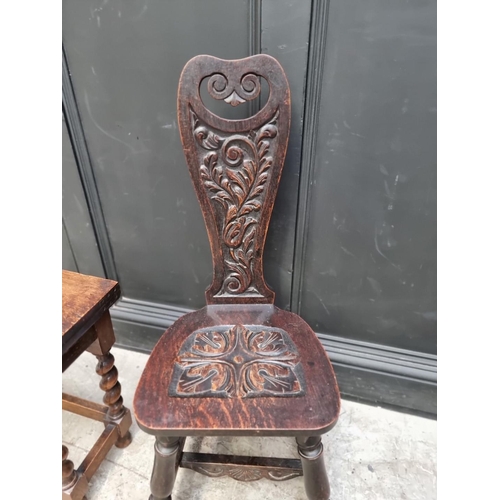 1079 - A 1920s carved oak spinning stool; together with another 1920s oak table, 38cm wide. (2)... 