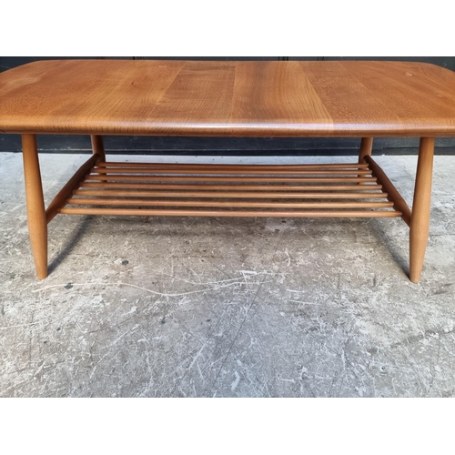 1091 - A vintage Ercol elm low occasional table, with spindle under tier, 104cm wide.