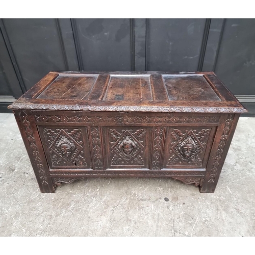 1094 - An interesting late 17th century carved oak panelled coffer, the front incorporating three stylised ... 