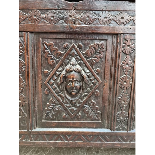 1094 - An interesting late 17th century carved oak panelled coffer, the front incorporating three stylised ... 