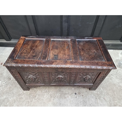 1094 - An interesting late 17th century carved oak panelled coffer, the front incorporating three stylised ... 