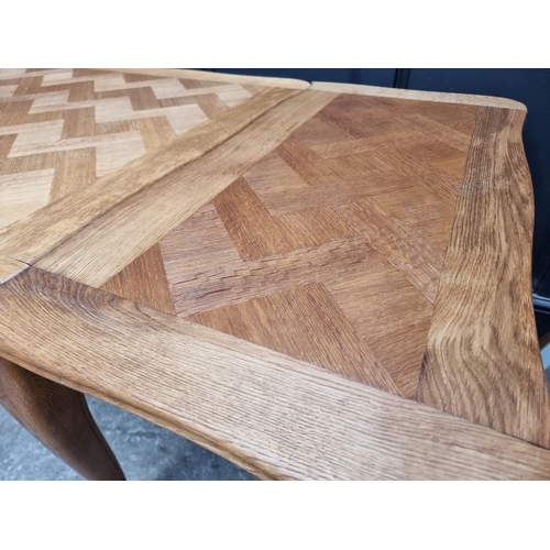 1114 - An oak draw leaf dining table, with parquetry top, 130cm when closed.