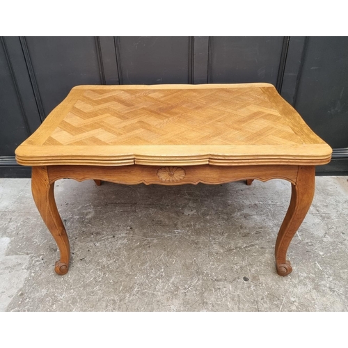 1114 - An oak draw leaf dining table, with parquetry top, 130cm when closed.