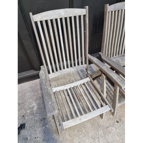 1136 - A pair of teak garden steamer chairs. (2)