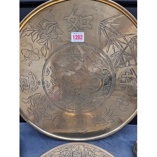 1202 - A small group of Chinese brassware, largest 38.5cm diameter. (4)