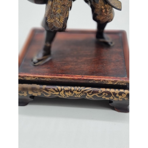 1228 - A Japanese bronze and parcel gilt figure of a Samurai, Meiji, signed Miyao, on hardwood stand, 23cm ... 