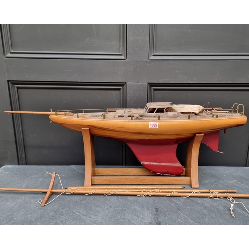 1335 - A vintage pond yacht, the hull 75cm long, on wood stand.