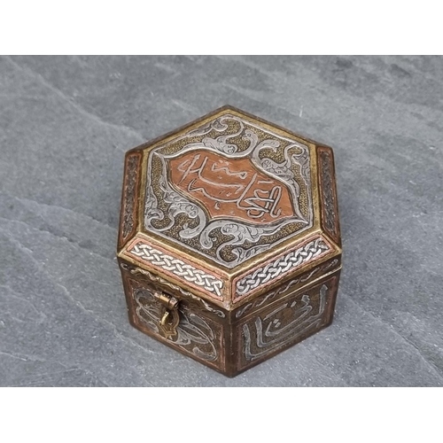 1351 - An Islamic Cairoware hexagonal casket, with script to hinged top, 10cm wide.