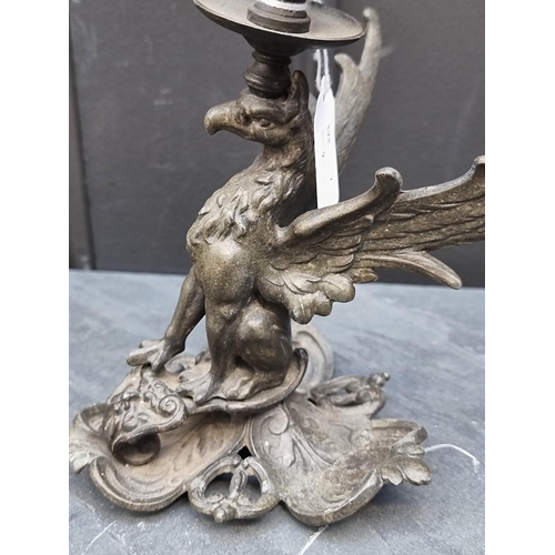 1409 - A bronze figural candlestick, 32cm high, together with another metal griffin candlestick, 19cm high.... 