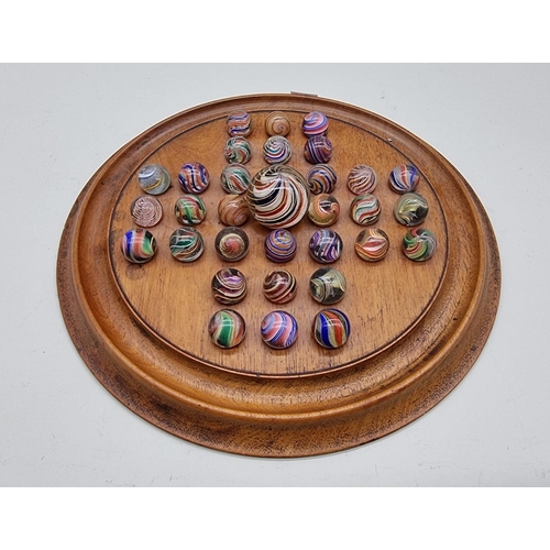1510 - A good set of thirty two antique glass marbles, each approx 20mm diameter, on mahogany solitaire boa...