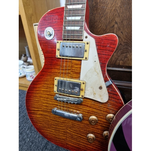 1553 - A cherry red sunburst 'Les Paul' style electric guitar, by Stagg; together with another electri... 