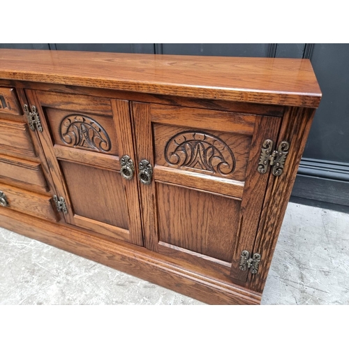 1009 - An 'Old Charm' oak low side cabinet, 183cm wide.