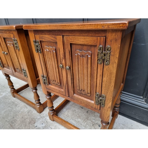 1016 - A pair of 'Old Charm' oak bedside cupboards, 50cm wide. (2)