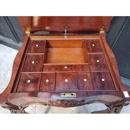 1035 - A 19th century continental mahogany work table, the hinged top enclosing an arrangement of pigeon ho... 