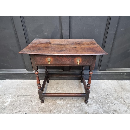 1061 - An early 18th century oak single drawer side table, 77.5cm wide.