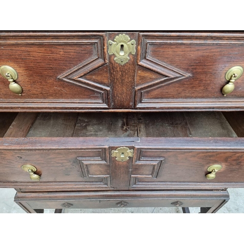 1063 - An antique oak geometrically moulded chest on stand, 102.5cm wide.