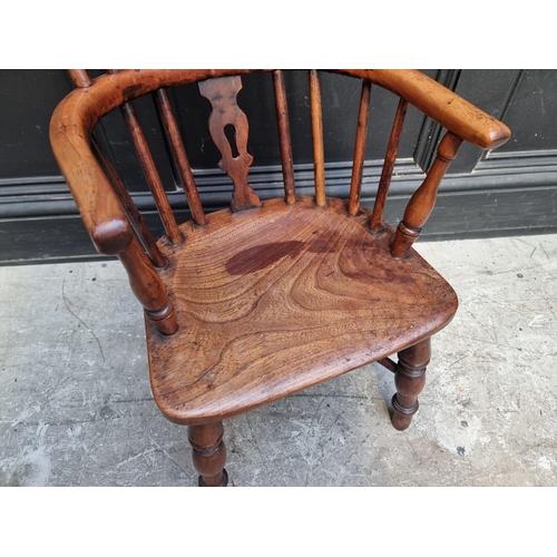 1070 - A scarce 19th century yew, elm and fruitwood childs' Windsor armchair.