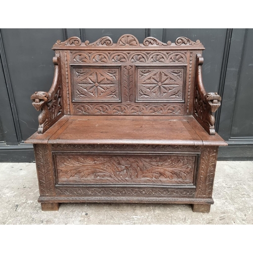 1073 - A circa 1900 carved oak box seat settle, 106cm wide. 