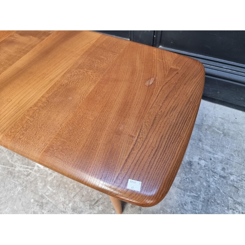 1091 - A vintage Ercol elm low occasional table, with spindle under tier, 104cm wide.