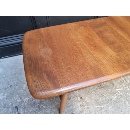 1091 - A vintage Ercol elm low occasional table, with spindle under tier, 104cm wide.