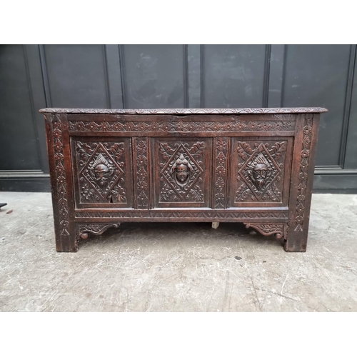 1094 - An interesting late 17th century carved oak panelled coffer, the front incorporating three stylised ... 