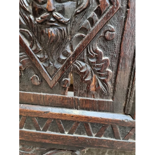 1094 - An interesting late 17th century carved oak panelled coffer, the front incorporating three stylised ... 