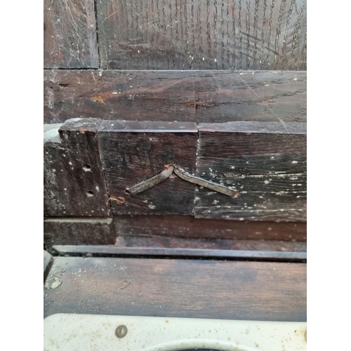 1094 - An interesting late 17th century carved oak panelled coffer, the front incorporating three stylised ... 