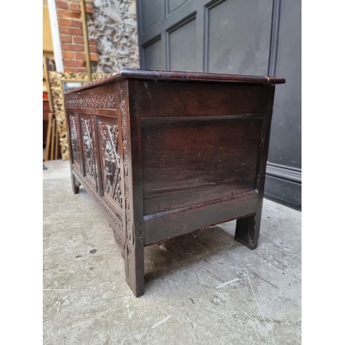 1094 - An interesting late 17th century carved oak panelled coffer, the front incorporating three stylised ... 