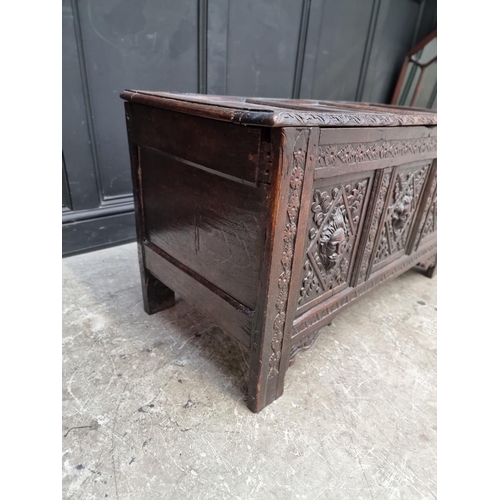 1094 - An interesting late 17th century carved oak panelled coffer, the front incorporating three stylised ... 