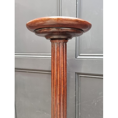 1109 - A pair of mahogany 'bedpost' tripod torcheres, 143.5cm high. (2)