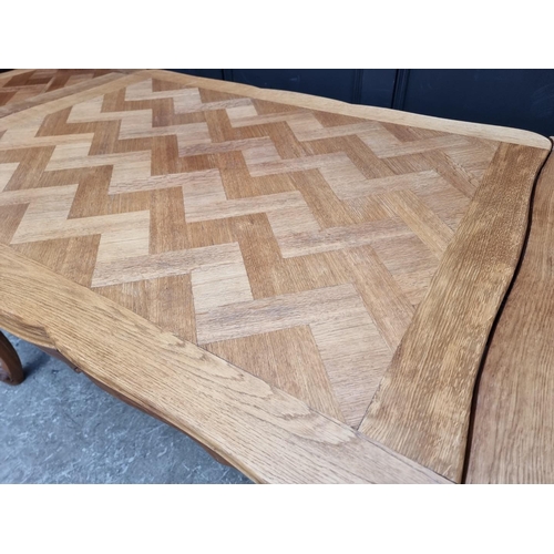 1114 - An oak draw leaf dining table, with parquetry top, 130cm when closed.